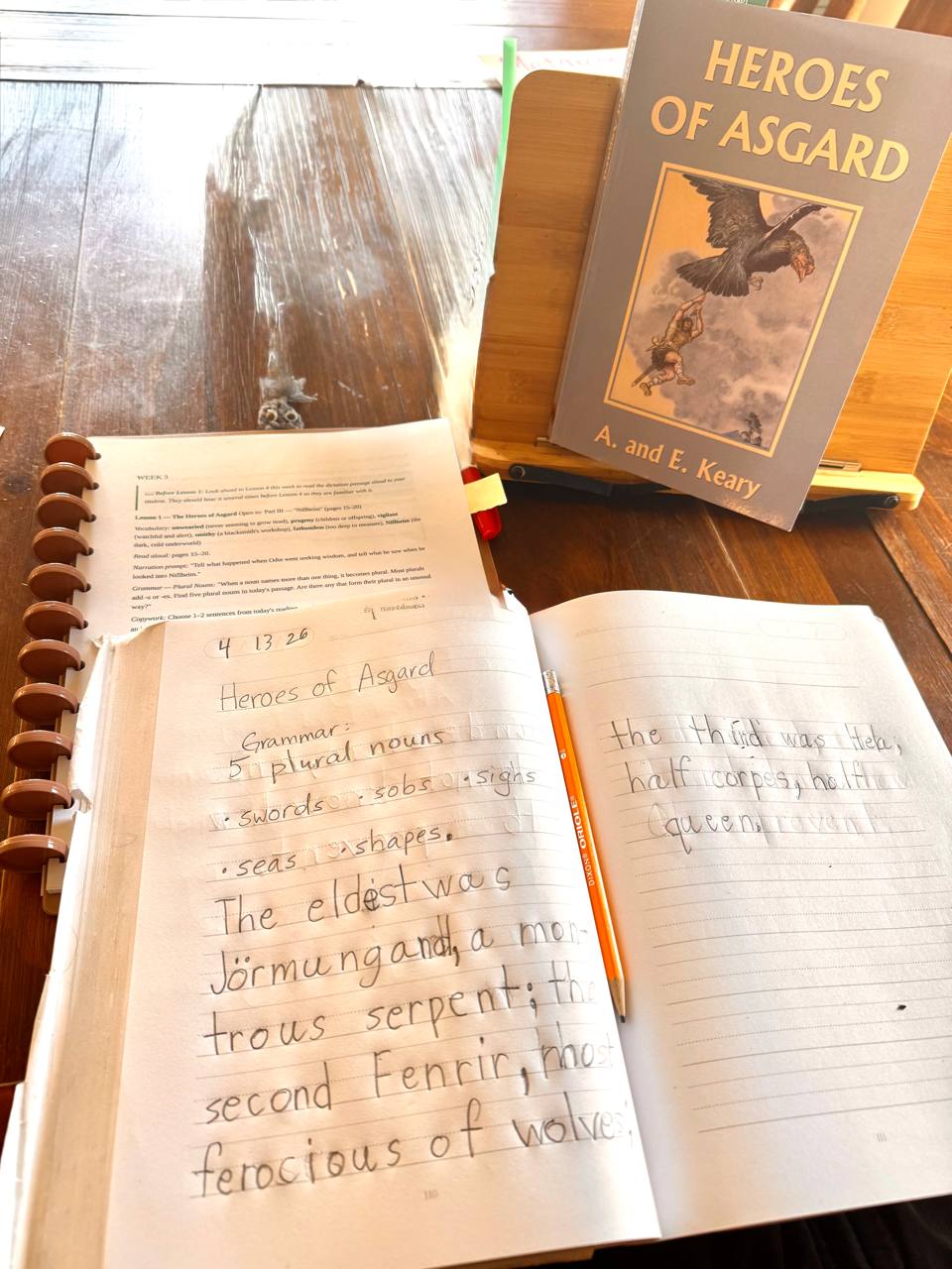 A child working on Fostering Wonder fourth grade English with Heroes of Asgard open on the table