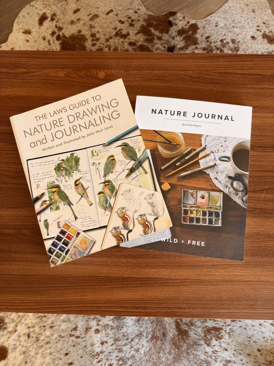 Nature drawing and nature journaling resources arranged on a wooden table