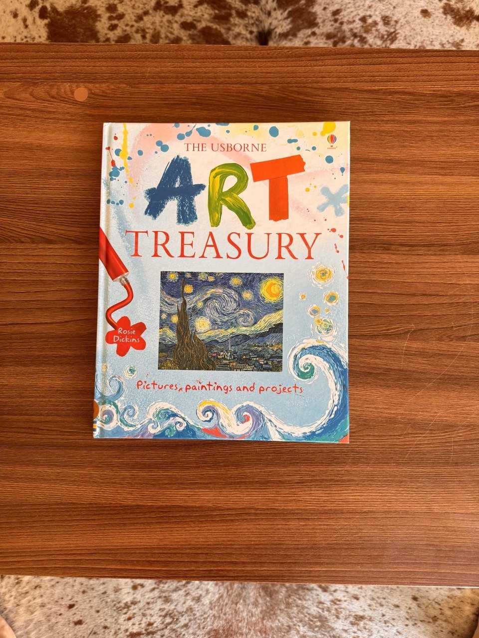 The Usborne Art Treasury book arranged on a wooden table